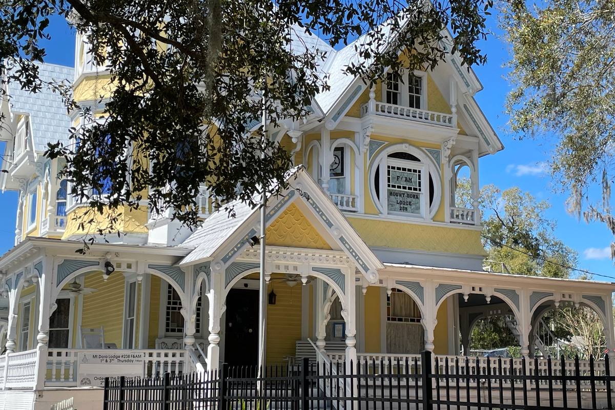 The Donnelly House, the yellow Victorian landmark in downtown Mount Dora, with gingerbread trim on its wraparound porch